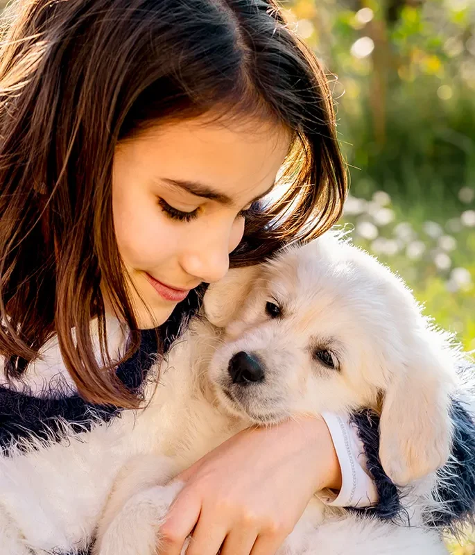 A girl hugging a fluffy golden puppy