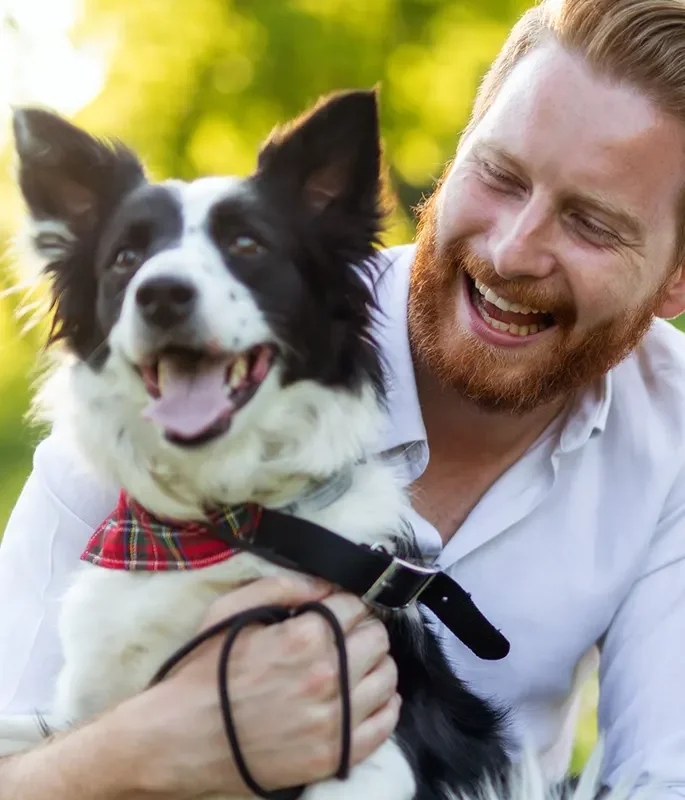 A smiling man with his border collie