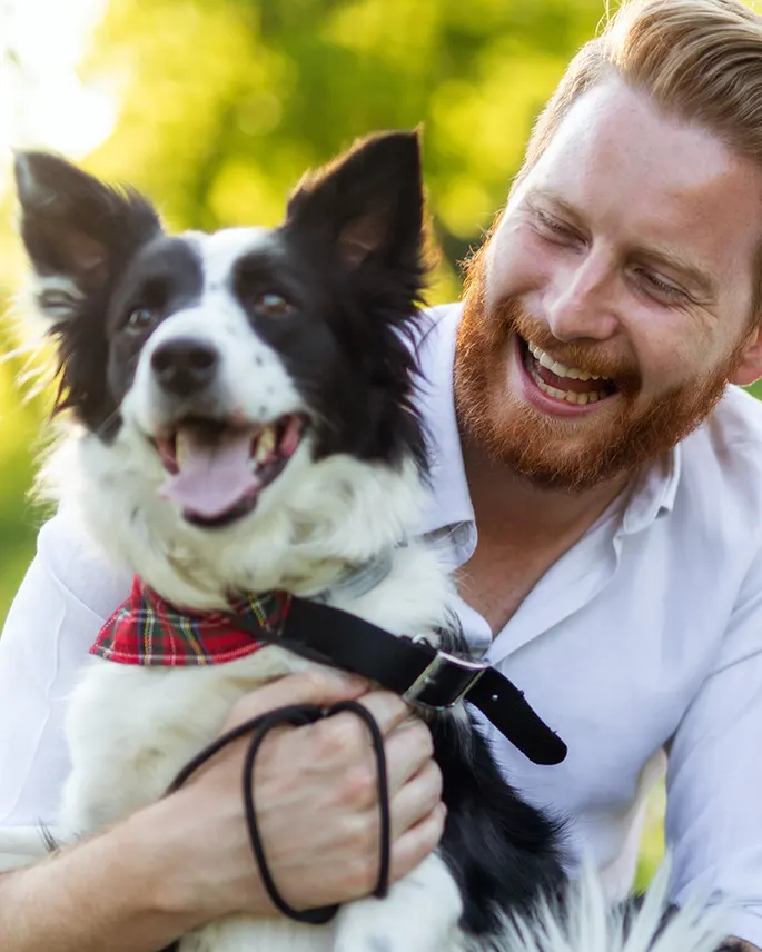 A smiling man with his border collie